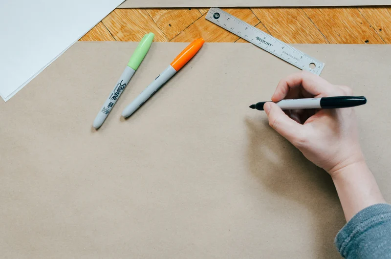 Hand drawing on kraft paper with markers and a ruler
