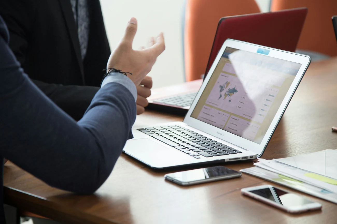 Two people discussing data on a laptop at a meeting table